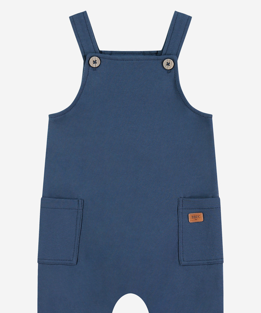 Details:&nbsp; Crafted from soft sweat material, these Baby Dungarees in Blue are the perfect addition to your little one's wardrobe. With a stylish dark blue hue and convenient pockets, these dungarees are both practical and comfortable. Perfect for all-day wear, your baby will look and feel great in these cozy dungarees.&nbsp;
Color:&nbsp;Dark blue&nbsp;&nbsp;
Composition: AW 24&nbsp;