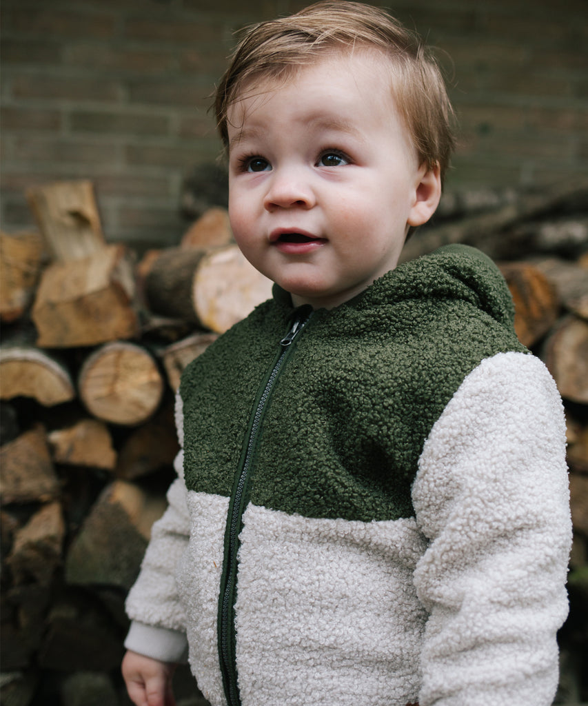 Details:&nbsp; &nbsp;This baby hooded teddy jacket in dark forest green and bone is perfect for keeping your little one warm and cozy. With a zip closure and pockets, it's also practical for parents on the go. Wrapping your baby in this soft and stylish jacket will provide both comfort and convenience while out and about. &nbsp;
Color: Dark Forest&nbsp;
Composition:&nbsp; 100% polyester &nbsp;