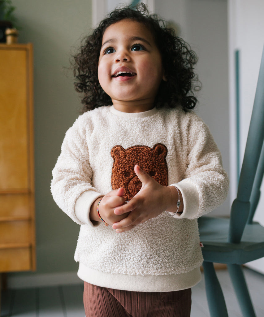 Details: &nbsp;This baby sweater is crafted from soft teddy fabric in a warm beige color, making it perfect for keeping your little one cozy. The adorable bear design on the front adds a playful touch, while the round neckline and ribbed arm cuffs and waistband provide a comfortable fit. A must-have for any stylish baby's wardrobe.&nbsp;
Color: Beige&nbsp;&nbsp;
Composition:&nbsp;100% polyester &nbsp;
