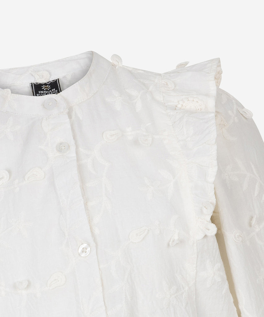 Details:&nbsp; Get the perfect blend of sophistication and edginess with our Ruffle Blouse in lily white . The embroided flowers adds a touch of elegance, while the white color maintains a bold and stylish look. Button closure on the front. Elevate any outfit with this must-have piece.&nbsp; Color: White&nbsp; Composition:&nbsp; 100% Cotton &nbsp;