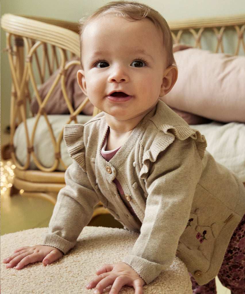 Details:&nbsp;This embrodied Baby Knit Cardigan is made with a soft knitted fabric, perfect for your little one's delicate skin. The button closure adds convenience and security, while the classic design allows for easy pairing with any outfit. Keep your baby cozy and stylish with this essential piece. Round Neckline.&nbsp; Color: Beige melee&nbsp; Composition:&nbsp; Organic Knit 100% Cotton &nbsp;