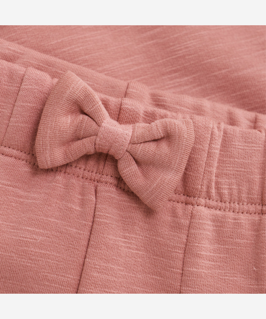 Details: These baby jogg pants are designed with comfort and style in mind. Soft and lightweight, each pair is equipped with an elastic waistband and a Bow on the front. Perfect for everyday wear.&nbsp; Color: Dusty rose&nbsp; Composition:&nbsp; Organic Sweat-slub Yarn 95% Cotton/ 5% Elastane &nbsp;