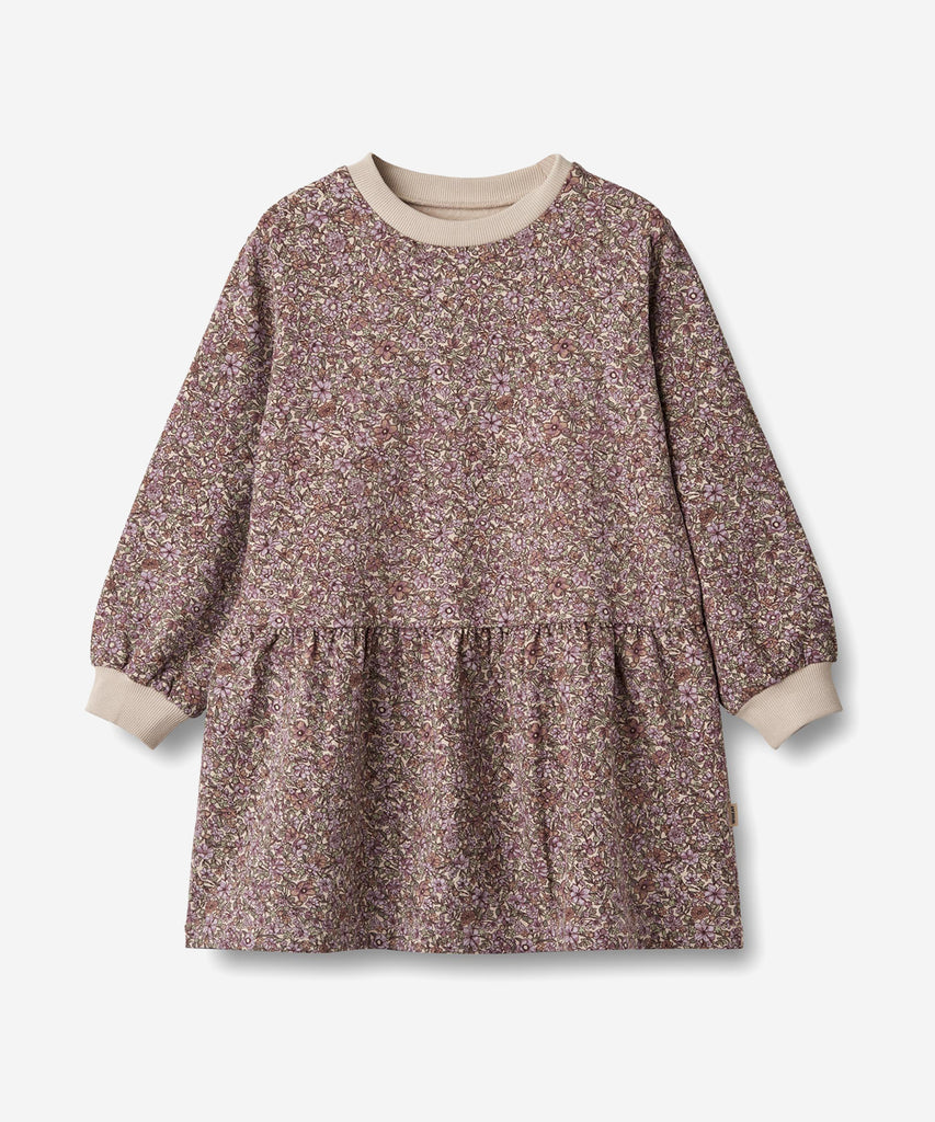 Details:
Long-sleeved sweat dress in soft brushed organic cotton for the junior child.
- Loose fit
- Length: above knees
- Soft rib at the neckline and cuffs
- Dropped shoulders
- Cutlines below the waist with gatherings below
- Hand drawn all-over print
Wheat's sweet dress has a loose fit, which makes it easy and comfortable for your child to wear. The dress has a flattering cutline with gatherings, which gives the dress some lovely volume. The dress is perfect for the autumn and winter months and can easi